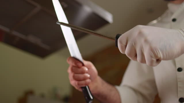 Close up of a chef sharpening his knife.