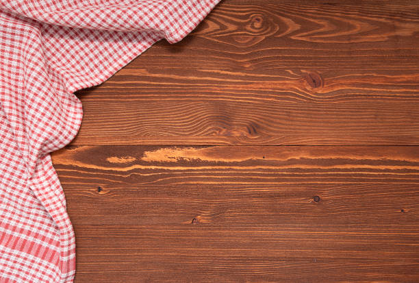 istock Checkered tablecloth or cloth napkin on wooden table with space for text, ideas. Top view 1317396580