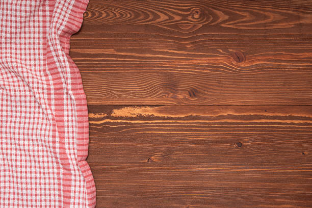 istock Checkered tablecloth or cloth napkin on wooden table with space for text, ideas. Top view 1317396591