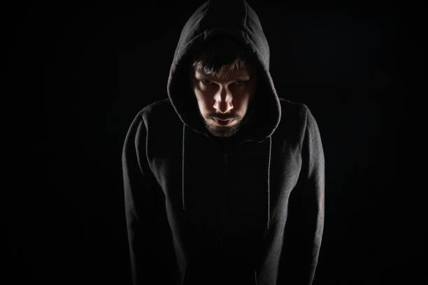 istock Scary stalker or hacker at night on black background. 1317397311
