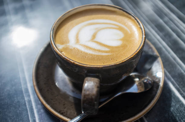istock Cup of fresh made coffee with flower design in foam 1317400453