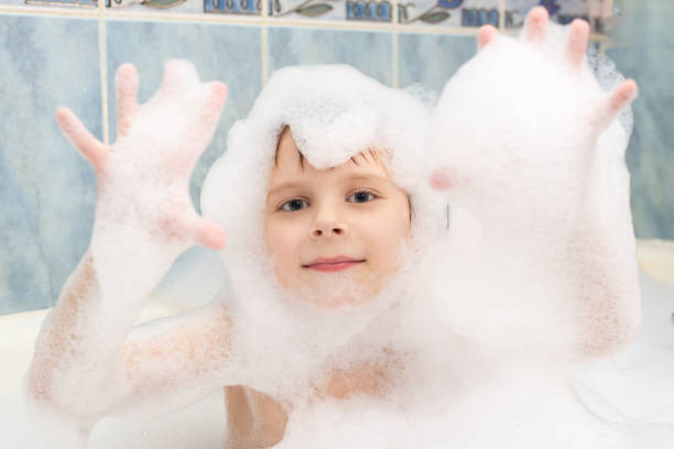istock A boy in soapy suds is washing in a bath. Hygiene, cleanliness concept. 1317403777