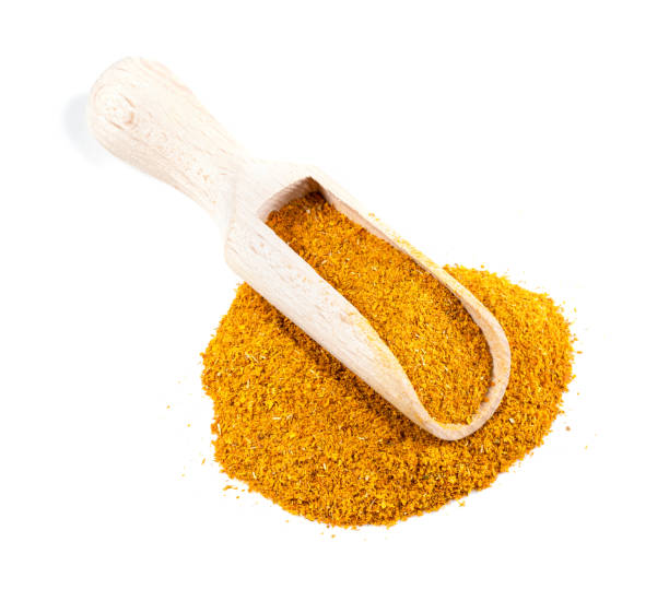 scoop on ground Dried Marigold Flowers on white wooden scoop on pile of ground Imeretian Saffron (Dried Marigold Flowers) on white background substitute for saffron stock pictures, royalty-free photos & images