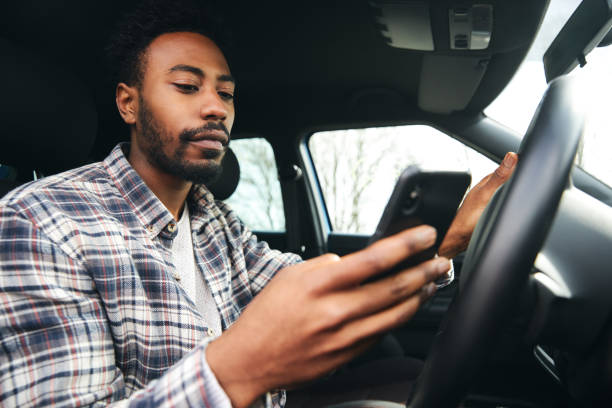 istock Dangerous Driving From Man Texting On Mobile Phone With One Hand On Steering Wheel 1317407433