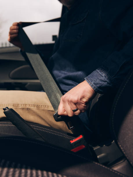 close up of male driver in car fastening seatbelt at start of journey - old men car vertical imagens e fotografias de stock