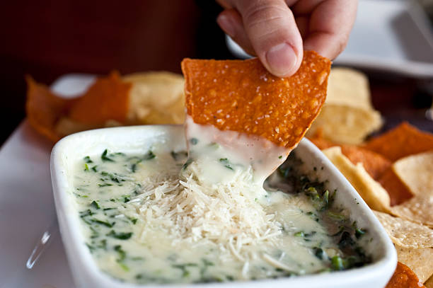 Spinach and parmesan cheese dip Spinach and parmesan cheese dip with tortilla chips dipping photos stock pictures, royalty-free photos & images