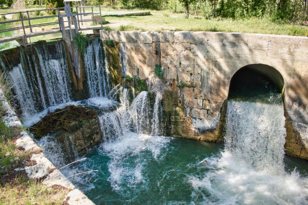 Water falls on the Viñalta lock bridge of the Castile Canal in Palencia province, Spain Waterfalls on the Viñalta Lock Bridge of the Castilla Canal in the province of Palencia, Spain sluice photos stock pictures, royalty-free photos & images