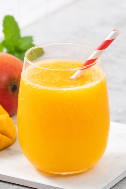 istock Fresh beautiful delicious mango juice smoothie in a glass cup on gray table background. 1317411262