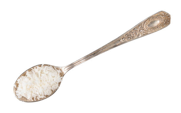 coconut flakes in silver spoon cutout on white top view of coconut flakes in silver spoon cutout on white background tsp stock pictures, royalty-free photos & images