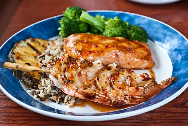 hawaiian camarones a la parrilla y filete de salmón - prepared shrimp skewer rice prepared fish fotografías e imágenes de stock