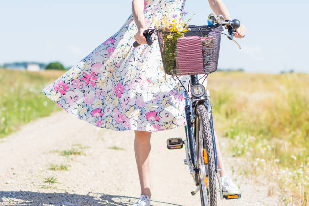 flores silvestres ramo en cesta de bicicleta con mujer en verano fondo de día ventoso - floral dress fotografías e imágenes de stock