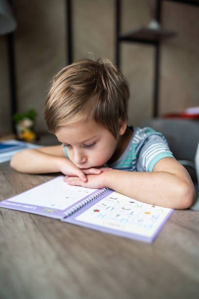 istock Little boy is tired of doing homework 1317415730