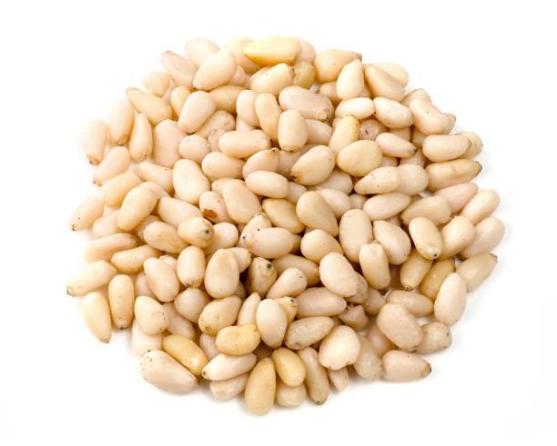 istock handful of unpeeled pine nuts closeup on white 1317415924