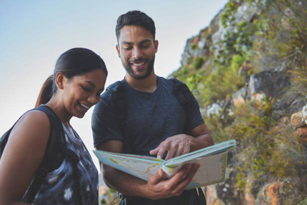 istock Shot of a young couple using a guide book to complete a hike in a mountain range 1317416944