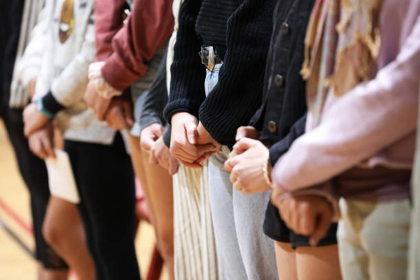 istock row of people with hands folded standing together 1317417128