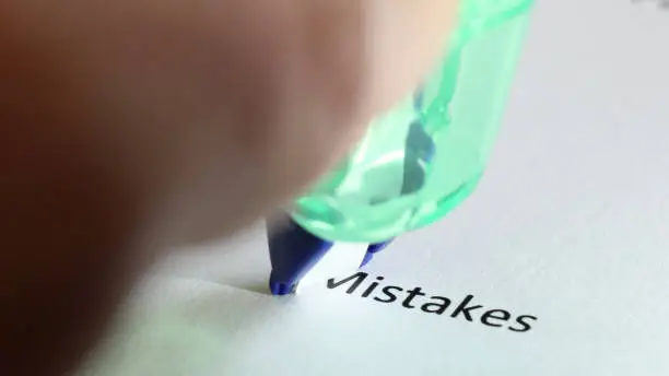 Photo of Erasing the typed word mistakes on paper using correction tape