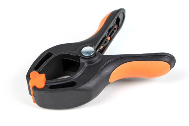 istock Plastic spring clamp isolated on white background. Clamping equipment. Working hand tool. Black and orange spring clamp. Closeup.. 1317418614