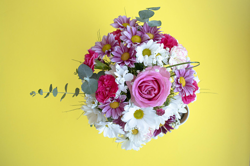 flowers bouquet on yellow background with planner.Gardening spring concept. stock photo...