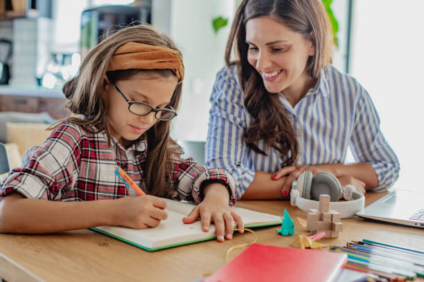 istock Mother helps her daughter to finish homework 1317423449