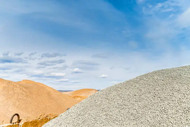 Photo of Materials for asphalt hot mix plant - sand and stones, clear blue sky, copy space