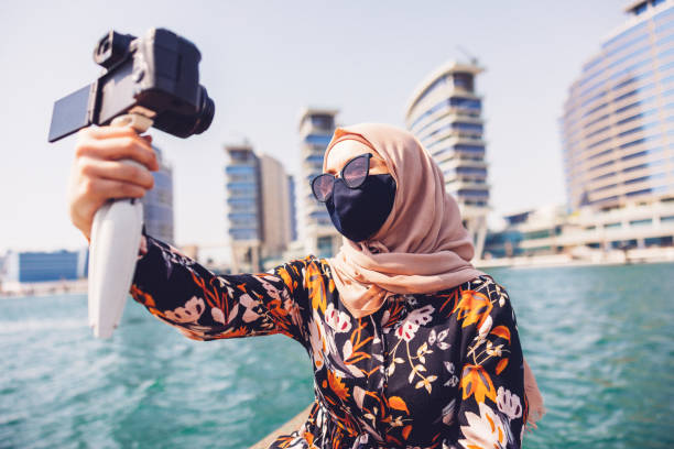 influenciadora de mídia social do oriente médio grava vlog em um barco - dubai media city - fotografias e filmes do acervo