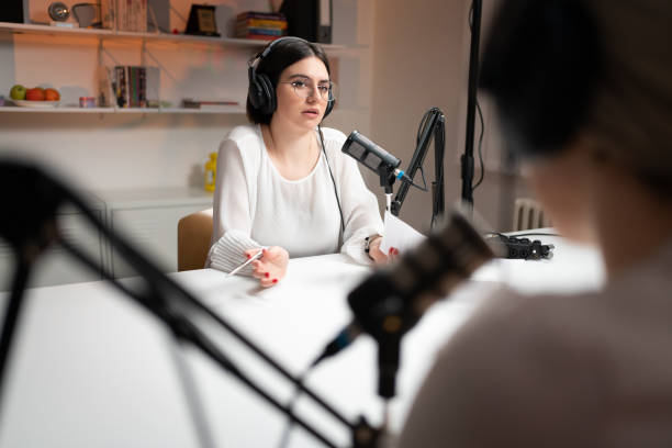 istock Young woman talking on the microphone during a podcast 1317428468