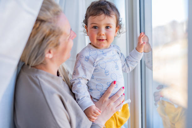istock Baby boy whit his mother by the window 1317432061