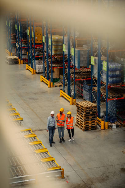 istock Three business people with safety helmet at warehouse 1317432495