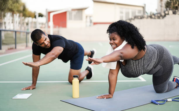 曲がりくねった女性とパーソナルトレーナーは、屋外でピラティスワークアウトセッションを行う - 女の子の顔に主な焦点 - yoga class instructor yoga exercising ストックフォトと画像