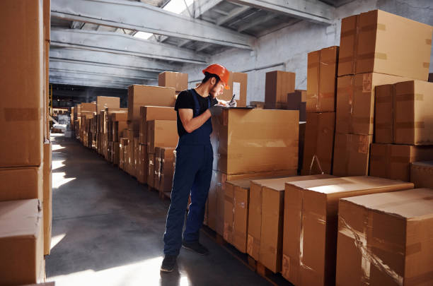 istock Storage worker in uniform and notepad in hands checks production 1317435679