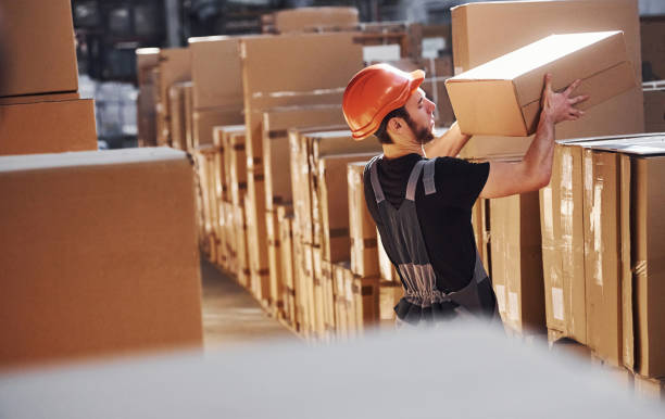 istock Young storage worker in warehouse in uniform busy with some work 1317435936