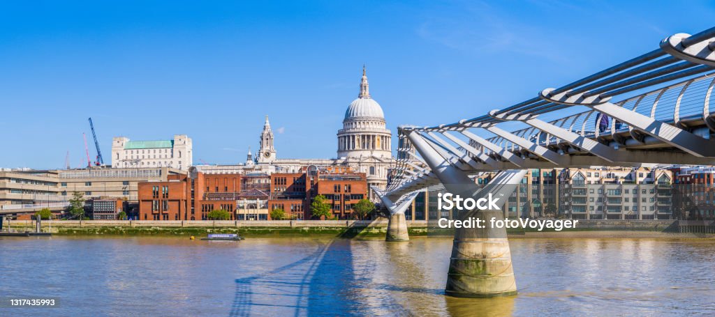 London St Pauls Cathedral Millenium Bridge River Thames panorama UK The futuristic glass and steel of the Millennium Bridge outside the Tate Modern spanning the River Thames at Bankside towards the iconic dome of St. Paul’s Cathedral in the City of London. London - England Stock Photo