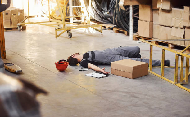 istock Warehouse worker after an accident in the storage. Man in uniform lying down on the ground 1317436202