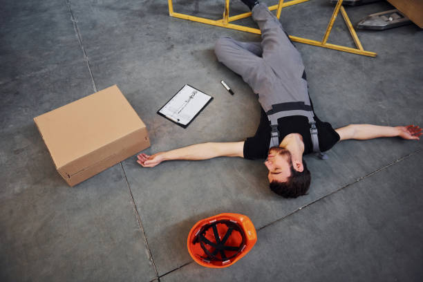 istock Warehouse worker after an accident in the storage. Man in uniform lying down on the ground 1317438759