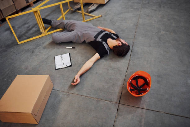 istock Warehouse worker after an accident in the storage. Man in uniform lying down on the ground 1317438797