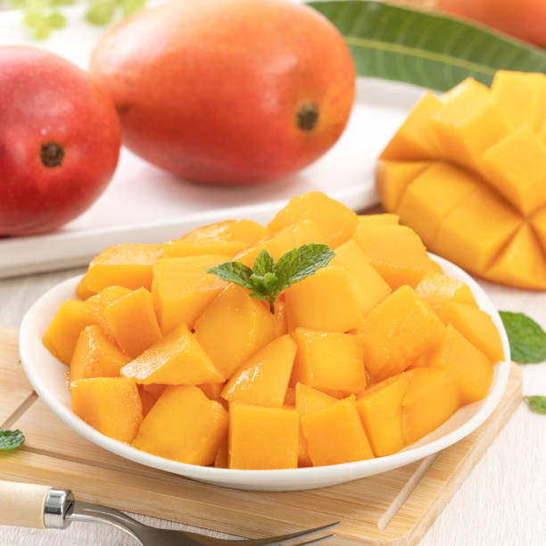 istock Diced fresh mango fruit on a white plate with leaves. 1317440230