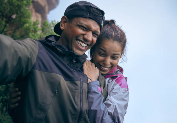 istock Cropped shot of an affectionate young couple laughing while taking a selfie during their early morning hike 1317441256