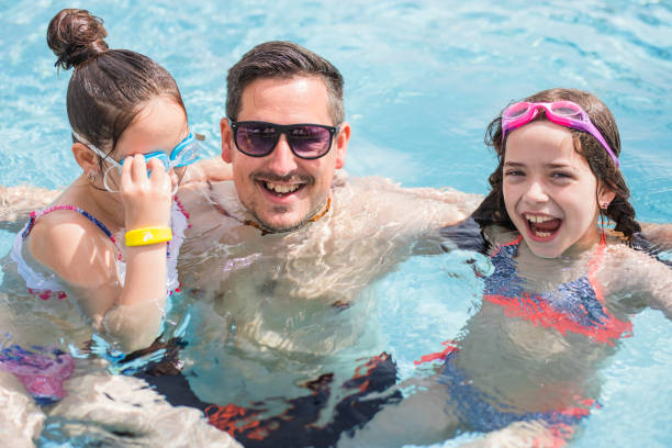istock Happy man having some proper summer fun at swimming pool with his daughters 1317441468