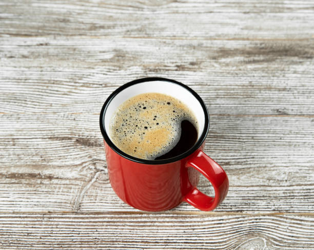 istock Red cup with black coffee on a brown wooden background. 1317442553