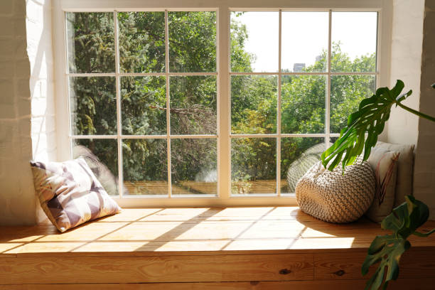 intérieur scandinave lumineux de pièce avec le monstera vert de plante et les lumières du soleil, le rebord blanc de fenêtre, les oreillers - window sill photos et images de collection