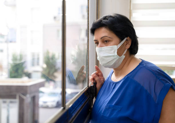 istock Senior woman wears protective face mask staying at home under quarantine 1317444094