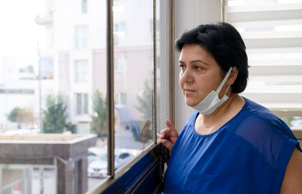 istock Senior woman wears protective face mask staying at home under quarantine 1317444148
