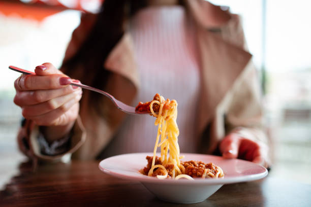 istock Woman eating spaghetti at a cafe 1317444278