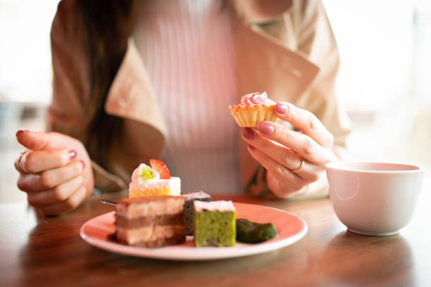 カフェでお菓子を食べる女性 - お菓子 ストックフォトと画像