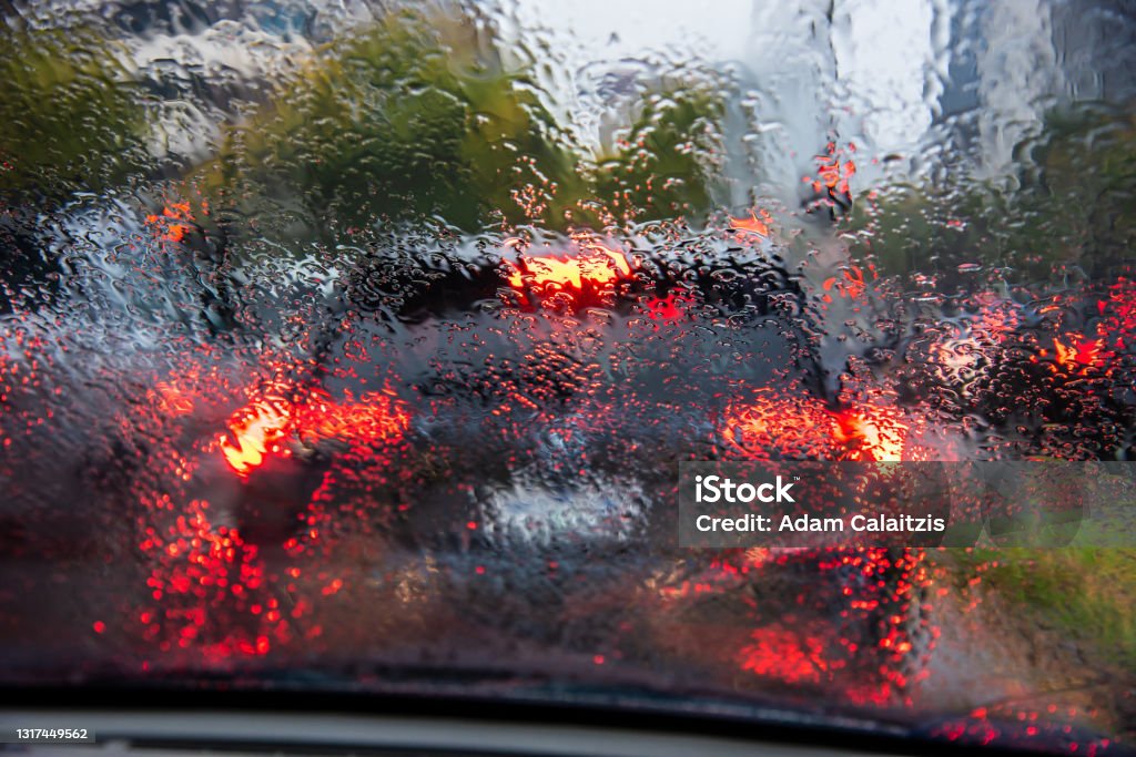 Looking through a wet drivers window at traffic Looking through a wet drivers window at traffic while stopped on a rainy morning rush hour Rain Stock Photo