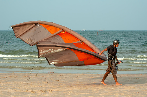 hua hin thailand may 4 2006   - unknown man carrying his kite sail on the beach in hua hin in thailand