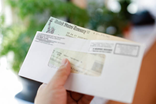 istock Man holding a tax refund check 1317449737