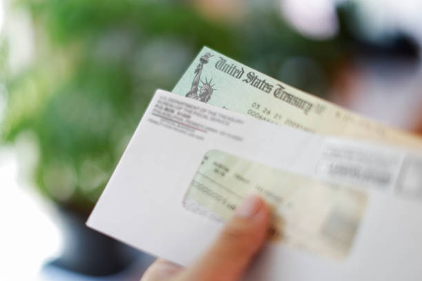 istock Man holding a tax refund check 1317449802