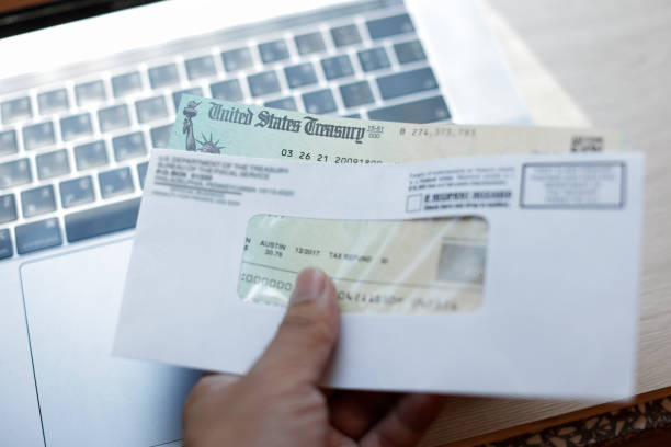 istock Man holding a tax refund check 1317449831