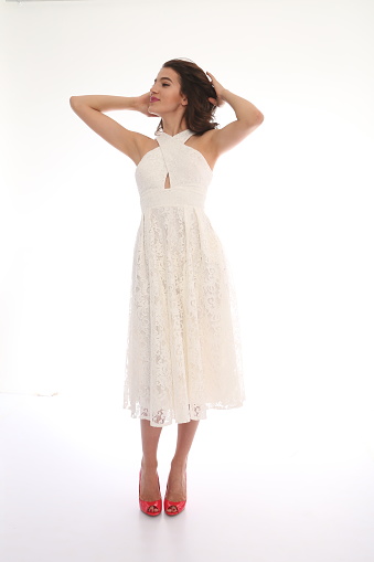 Young beautiful woman in invitation dress. studio shot. white background. fashion shot. raw photo.